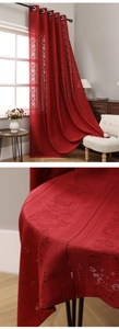 Detail of burgundy lace curtains and tablecloth with floral hollow patterns