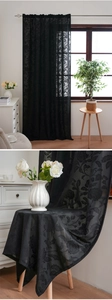 Macro shot of black bohemian lace curtain fabric with intricate floral rose patterns