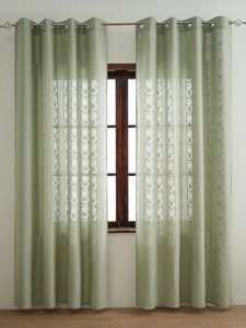 Detail of light green lace curtain with floral texture and silver grommet hanging style