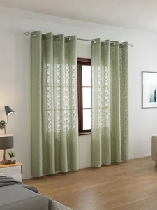 Sage green lace curtain detail featuring metal grommets and delicate floral embroidery patterns