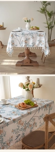 Macro view of floral and bird print linen tablecloth with beige tassel fringe details