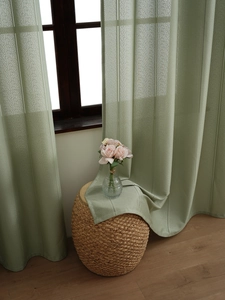 Detail of light green vertical striped sheer curtain with textured fabric and soft drape