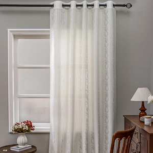 White semi-transparent lace curtains with floral embroidery and top metal grommets