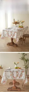 Close-up of floral pattern linen tablecloth with decorative white tassel fringe details