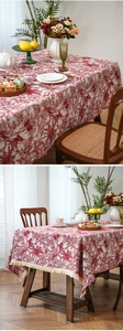 Close-up of vintage red forest pattern jacquard tablecloth with creamy white fringe edges