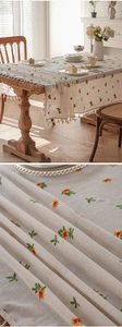 Detailed macro view of yellow flower embroidery and fringe edge on linen tablecloth