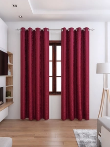 Detail of burgundy blackout curtain featuring floral jacquard and grommet top design