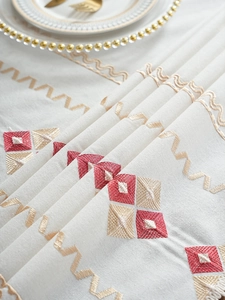 Detailed close-up of geometric diamond embroidery on beige waterproof cotton-linen tablecloth