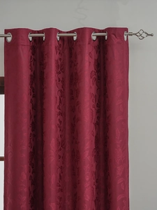 Close-up of wine red blackout curtain with floral jacquard and silver metal grommets