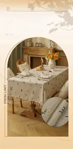 Linen tablecloth with pastoral plant embroidery and tassel trim on wooden table