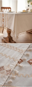 Detailed embroidery of geometric diamond patterns and tassel fringe on a boho tablecloth