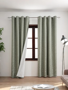 Detail of grey-green blackout curtain with white floral leaf patterns and metal grommets