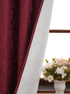 Close-up of luxury burgundy damascus curtains with thick blackout lining and lace coating