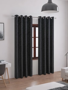 Close-up of black blackout curtains featuring embossed floral texture and metal grommets