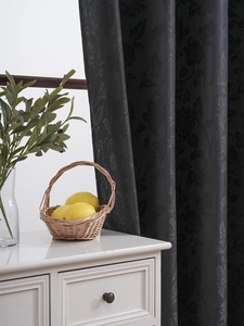 Detail of black floral jacquard blackout curtain with elegant silk texture for home decor
