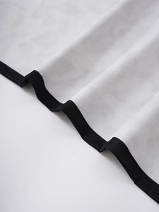 Close-up of white waffle texture fabric with premium black ribbed edge stitching detail