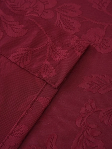 Detailansicht von weinrotem Jacquard-Stoff mit geprägtem Rosenmuster und feiner Textur