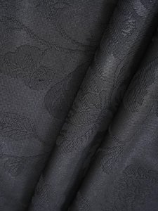 Macro shot of luxury burgundy blackout curtain fabric with intricate floral jacquard texture