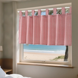 Detailed view of red and white gingham cafe curtain with strap loops against a beach view