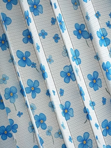 Detail of grey pleated door curtain with delicate blue floral print for kitchen partition