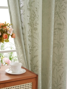 Detail der hellgrünen Spitzenvorhänge mit eleganter Blattstickerei für das Wohnzimmer