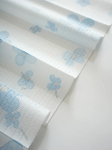 Detail of a light blue floral pattern on white mesh fabric for folding door curtains