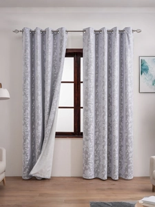Close-up of floral jacquard texture and silver metal grommets on retro curtains