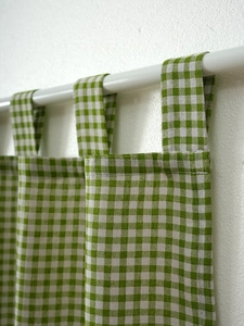 Detail of green and white gingham tab top cafe curtain with neat stitching and cotton texture