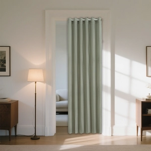 Detail view of sage green pleated folding door curtain with grommet top in home setting