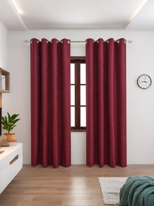 Detailed texture of burgundy blackout curtains with embossed floral leaf patterns