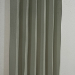 Close-up of grey-green pleated folding door curtain with fine horizontal woven textures
