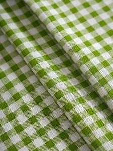 Macro detail of the green gingham cotton fabric texture and soft hanging drape