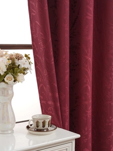 Detail of burgundy blackout curtain with floral jacquard texture and elegant home decor