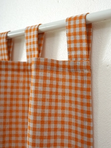 Close-up of orange gingham tab top curtain showing cotton texture and neat stitching details