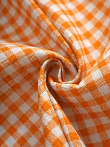 Macro shot of orange and white plaid fabric texture for minimalist cafe curtains