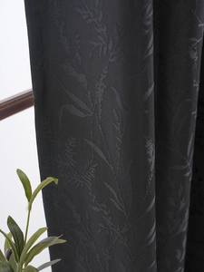 Detail of premium black blackout curtain featuring 3D embossed floral patterns and texture