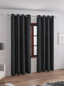 Detail of black blackout curtain with floral patterns and silver metal grommets