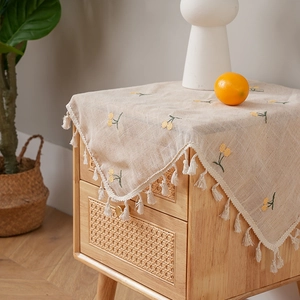 Pastoral linen tablecloth with yellow cherry embroidery and white fringe tassels on wood