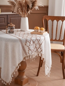 Detailed view of bohemian thick linen tablecloth with brown geometric embroidery and tassels