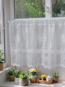 Detail of white lace cafe curtain with palm tree pattern and scalloped wave edge