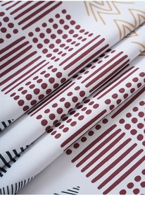 Close-up detail of geometric printed blackout curtain fabric with burgundy and black patterns