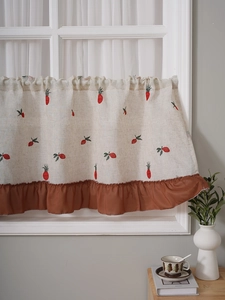 Detail of embroidered linen cafe curtain with red berry patterns and ruffled edges