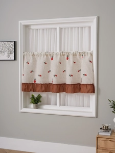 Detail of small fruit embroidery and burgundy ruffled hem on linen coffee curtain