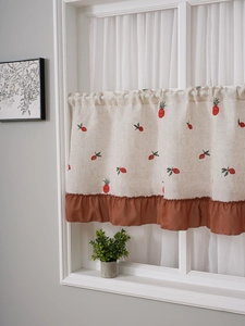 Detailed embroidery of red pineapple pattern on linen cafe curtain with ruffled hem
