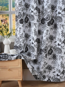 Detailed texture of white blackout curtains with black floral prints in a sunlit room