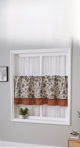 Detail of floral cafe curtain with ruffled trim and natural cotton linen texture
