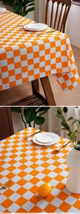 Close-up of orange checkerboard tablecloth showing linen texture and elegant drape on wood