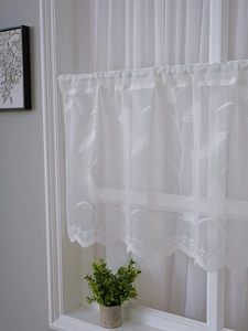 Close-up of white lace cafe curtain featuring elegant wheat embroidery and scalloped edges