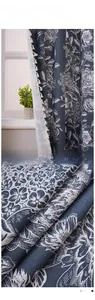 Détail de rideau floral bleu marine avec pompons crème élégants et tissu en lin texturé