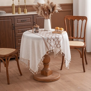 French country style linen tablecloth with tassels and brown embroidery on round table